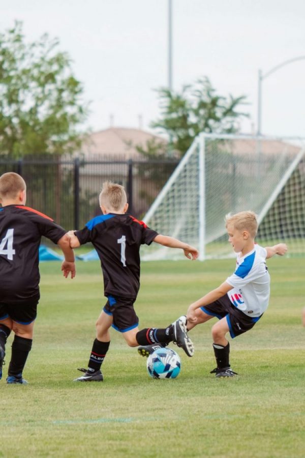 three children playing football