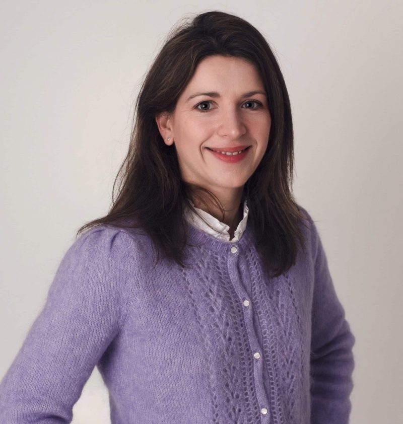 woman in purple cardigan smiling