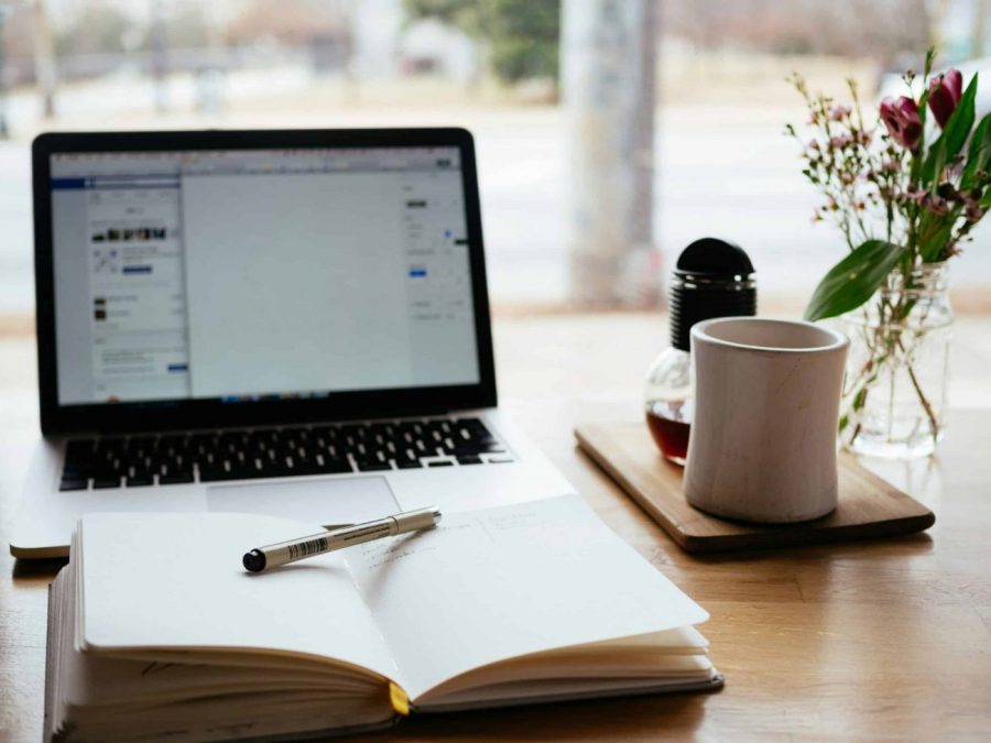 desk with a notebook and laptop