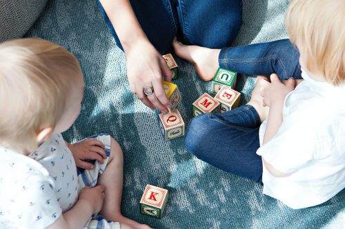 two toddlers with alphabet blocks