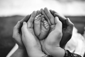 adult hands holding baby feet